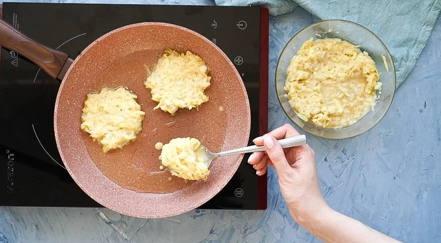 Draniki werden wie Pfannkuchen in die Pfanne gelöffelt