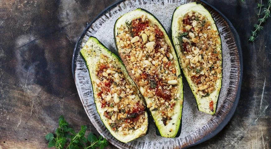 Im Ofen gebackene Zucchinischiffchen mit Tomaten, Hüttenkäse und Nüssen