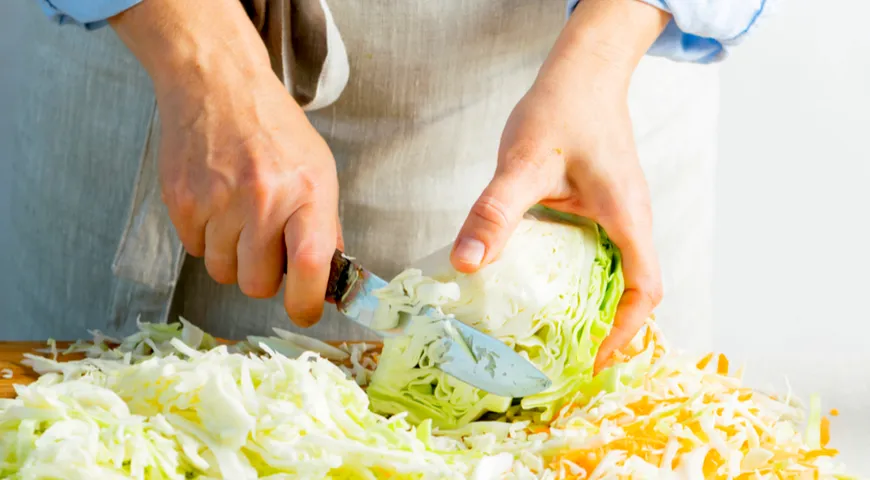 Einen Kohlkopf zerkleinern, um Sauerkraut herzustellen