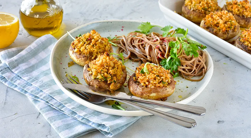 Im Ofen gebackene und mit brotwürziger Füllung gefüllte Champignons und Buchweizen-Soba-Nudeln