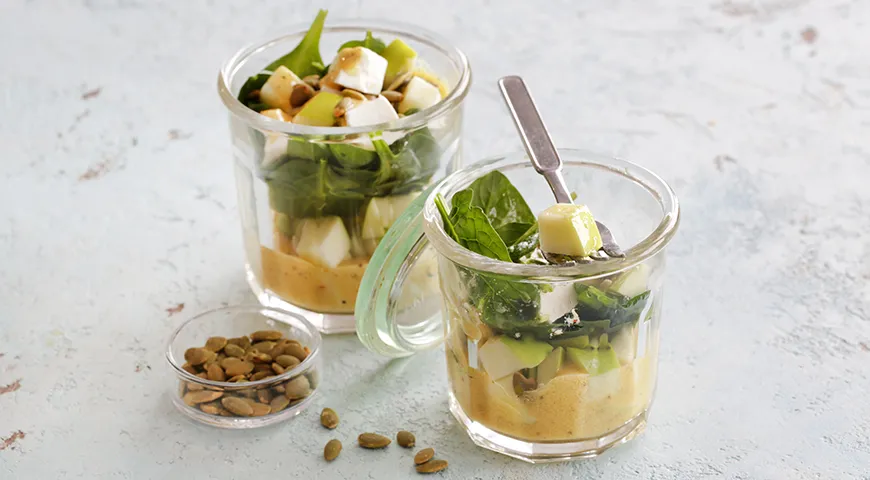 Salat mit Apfel, Spinat und Käse im Glas zum Mitnehmen