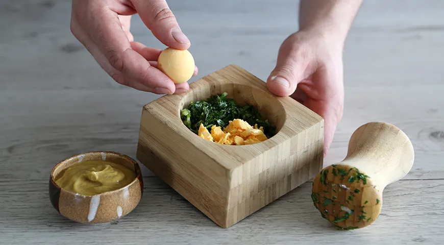 Bereiten Sie ein Dressing für Okroshka aus Eigelb, Frühlingszwiebeln, Salz und Senf mit gemahlenem schwarzem Pfeffer zu, falls gewünscht