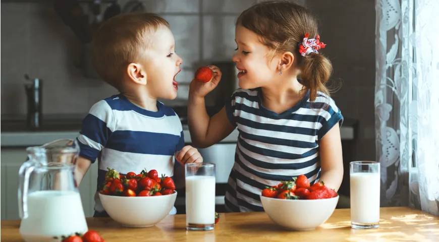 Wir essen Erdbeeren mit Milch