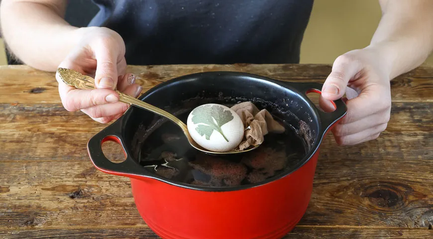 Die Eier mit Zwiebelschalen und Kräuterblättern dekorieren (Schritt 4)